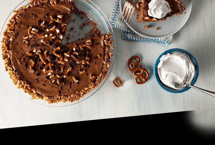 Table with vegan chocolate mousse topped with crushed pretzels and chocolate