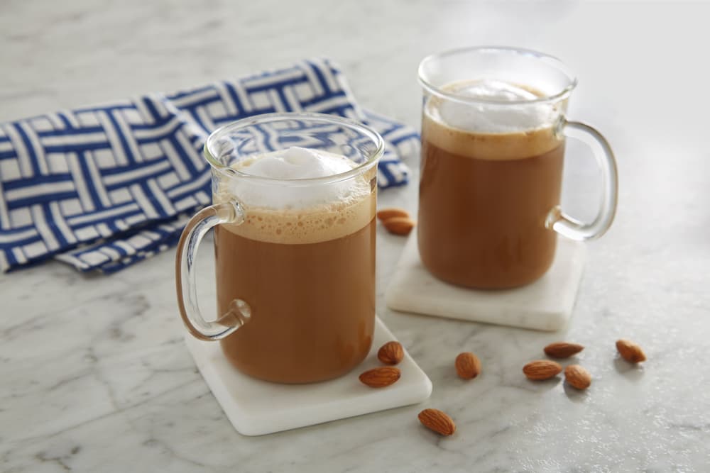 Almondmilk flat white in two clear mugs on a countertop