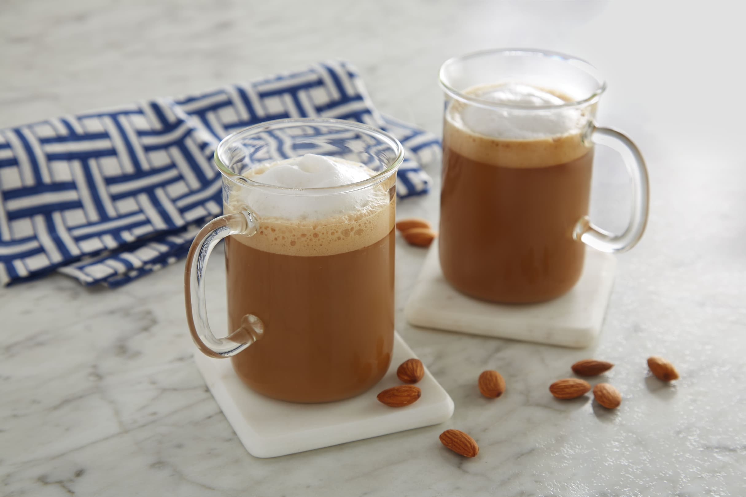Almondmilk flat white in two clear mugs on a countertop
