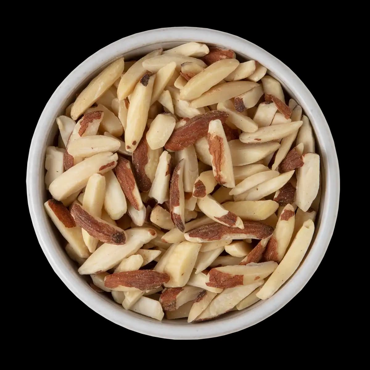 A white bowl filled with slivered almonds, some with skin on, set against a black background.