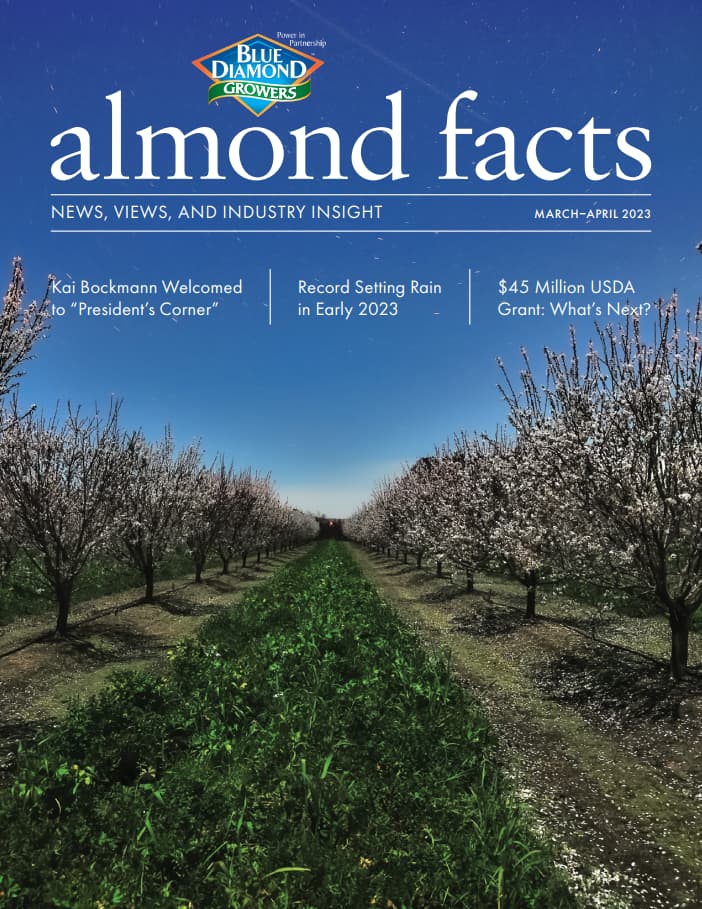 Cover of Almond Facts magazine showing rows of almond trees in bloom under a blue sky, with headlines about industry news and insights.