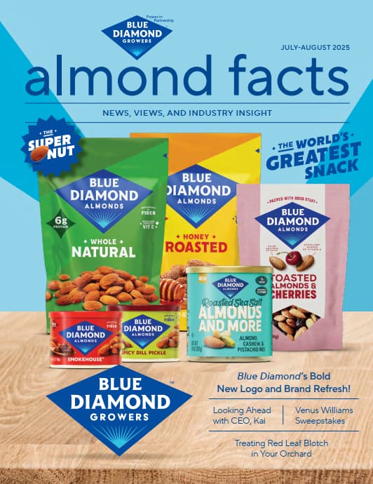 Five colorful Blue Diamond almonds packages are arranged upright on a blue surface. The almond facts magazine cover highlights branding, product varieties, and featured article headlines.