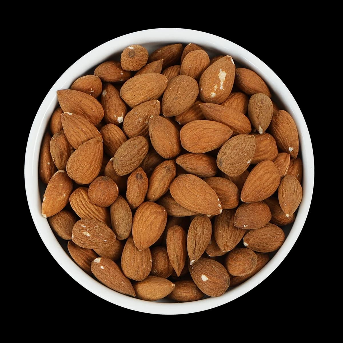 A white bowl filled with unshelled almonds is shown from above against a black background.