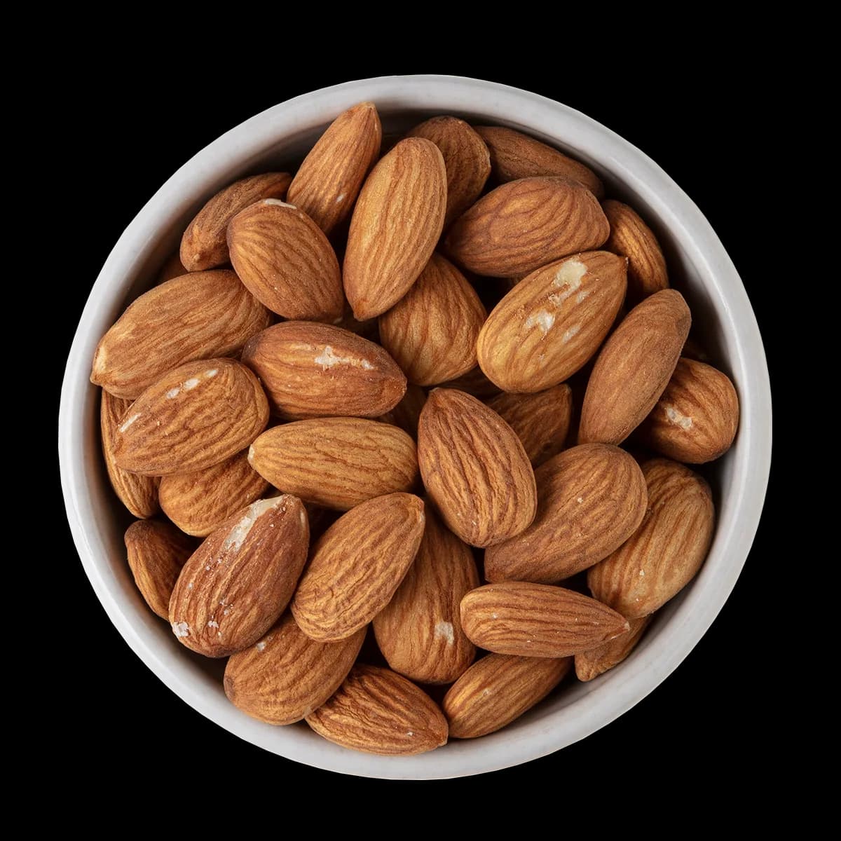 A white bowl filled with whole, unshelled almonds is shown against a solid black background.