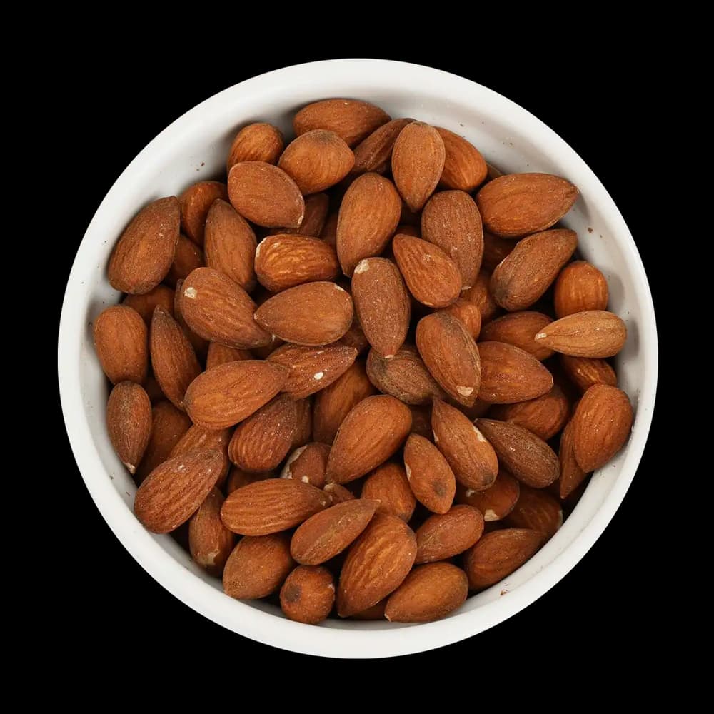 A white bowl filled with whole, unpeeled almonds is shown against a black background.