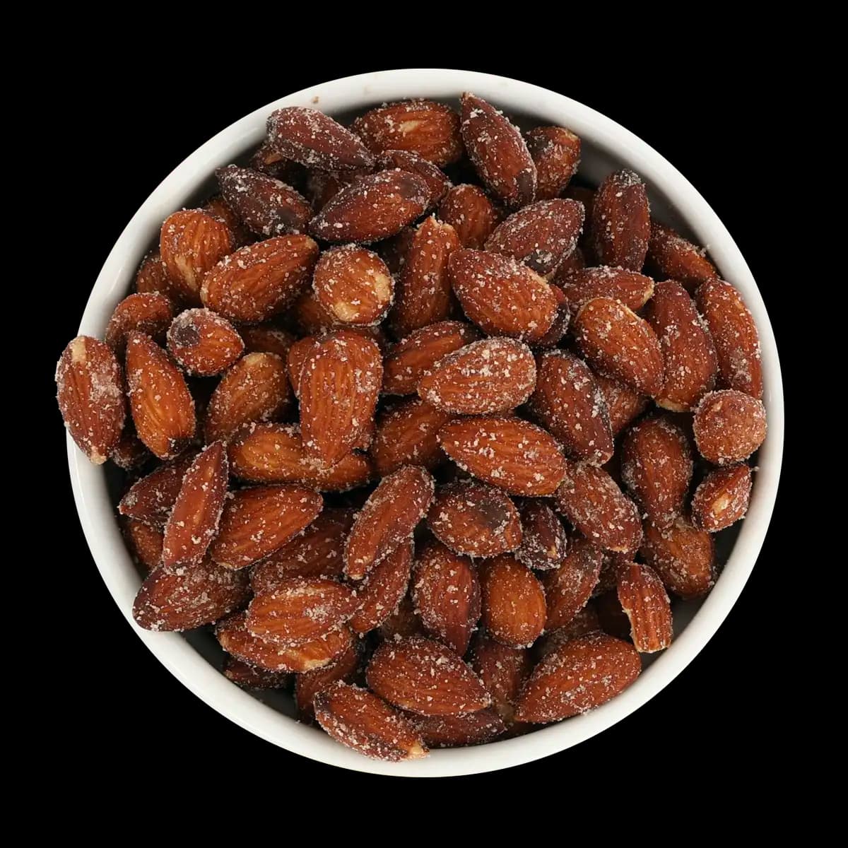 A white bowl filled with roasted almonds coated in salt, photographed from above on a black background.