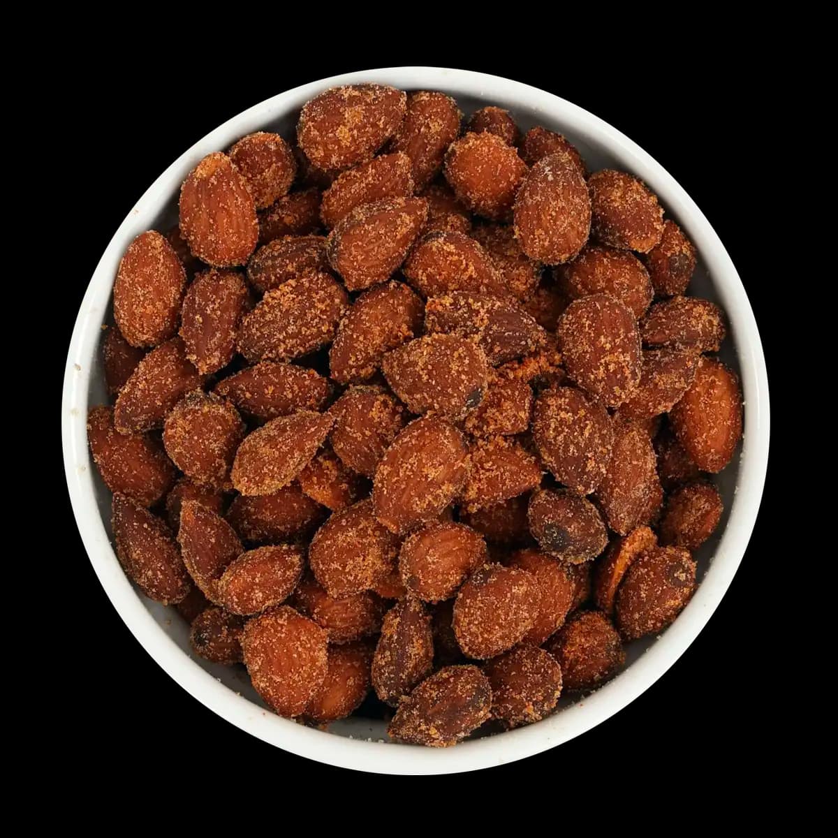 A white bowl filled with roasted almonds coated in a reddish seasoning, set against a black background.