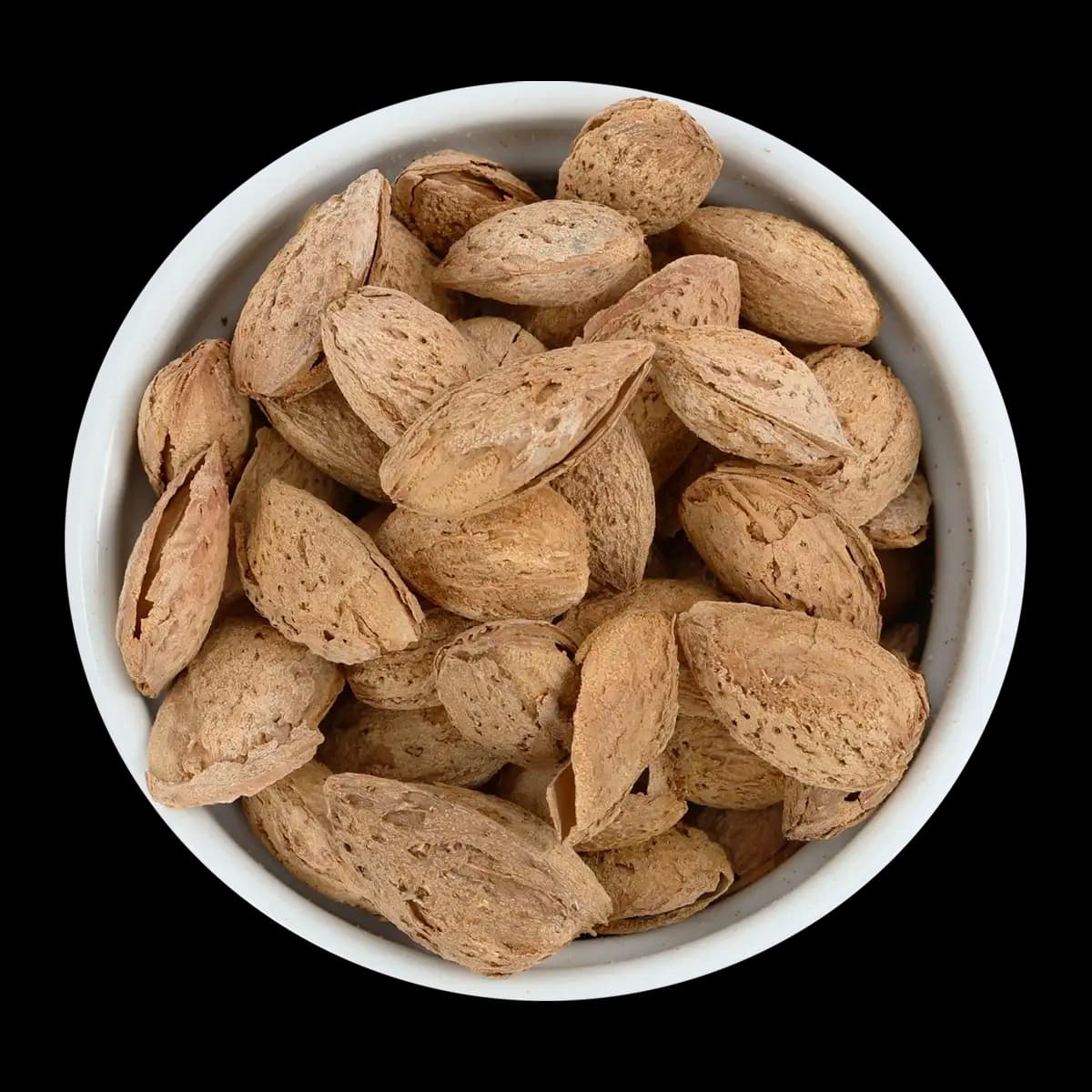 A white bowl filled with whole unshelled almonds is shown against a black background.