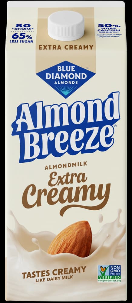 Carton of Blue Diamond Almond Breeze Extra Creamy almondmilk with an almond splashing into a pool of milk at the base.